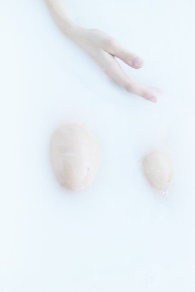 Body in bath where only the right hand and the knees are visible
